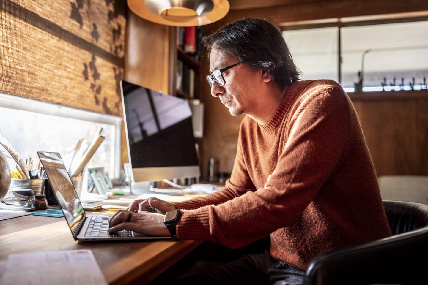 Man using laptop and paying bills in home office